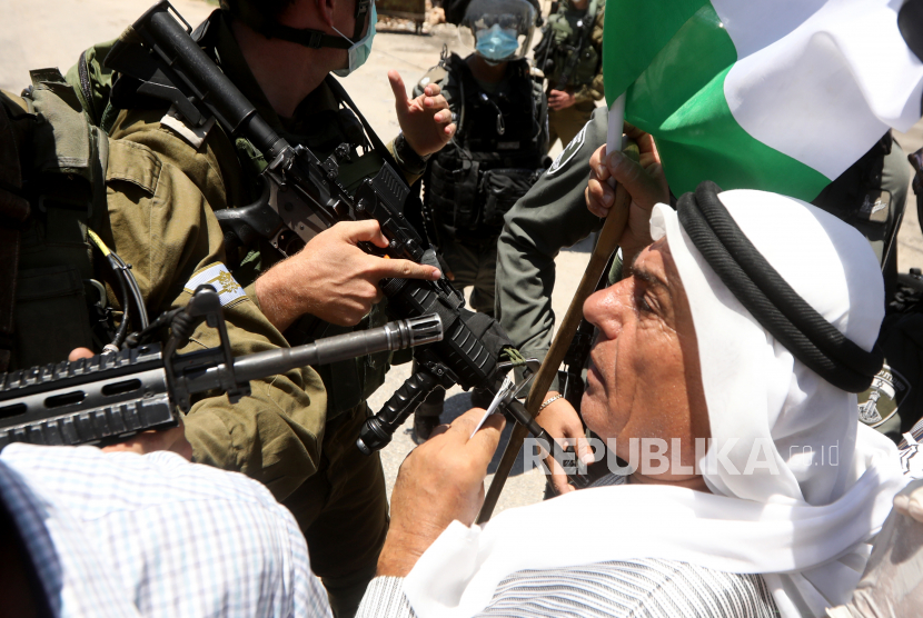  Pemrotes Palestina berdebat dengan tentara Israel ketika mereka mencoba untuk mencapai tanah mereka selama demonstrasi menentang rencana Israel untuk mencaplok bagian-bagian Tepi Barat yang diduduki di desa Hares dekat kota Salfit di Tepi Barat utara, 26 Juni 2020. 