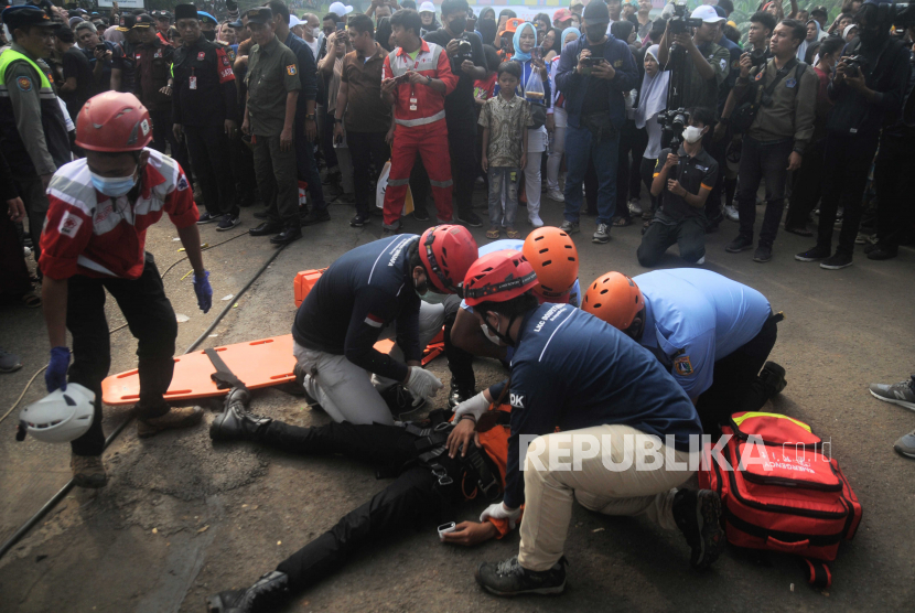 Petugas memberikan pertolongan pertama kepada korban saat simulasi bencana. Pemprov DKI Jakarta memfasilitasi akses peringatan dini banjir secara daring.