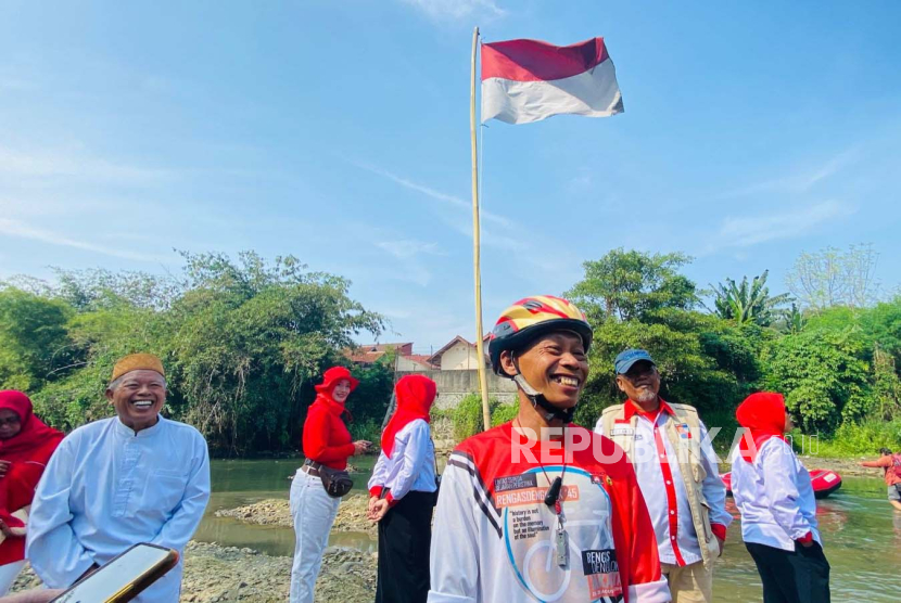 Anggota Komunitas Peduli Ciliwung (KPC) yang juga River Defender, Suparno Jumar, turut membersihkan sampah di Sungai Ciliwung usai upacara pengibaran bendera, Kamis (17/8/2023). 