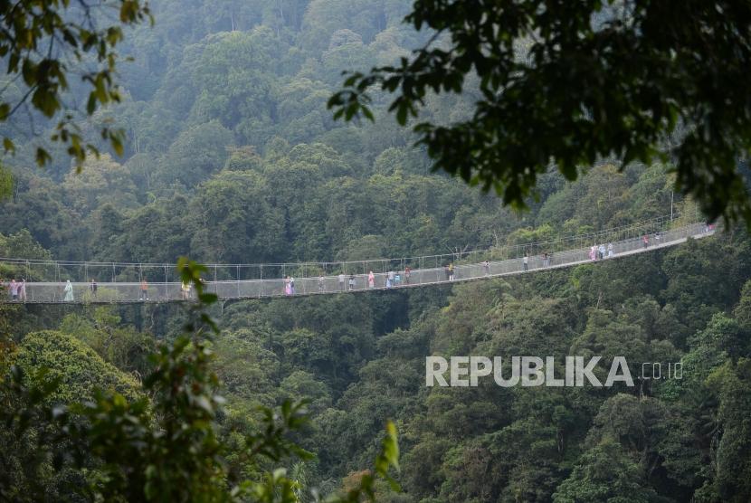 Wisatawan  melintasi Situ Gunung Suspension Bridge di Taman Nasional Gunung Gede Pangrango.
