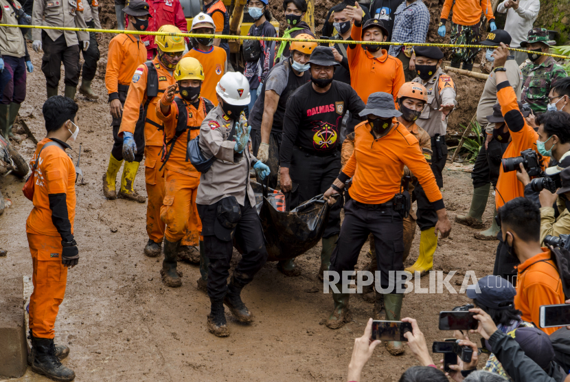 Petugas SAR gabungan mengevakuasi jenazah korban tanah longsor di Cimanggung, Kabupaten Sumedang, Jawa Barat, Minggu (10/1/2021). Tanah longsor yang diduga terjadi akibat intensitas curah hujan yang tinggi pada Sabtu (9/1) sore tersebut mengakibatkan 12 orang korban meninggal dua dan belasan orang diperkirakan masih tertimbun serta 14 bangunan rusak berat. 