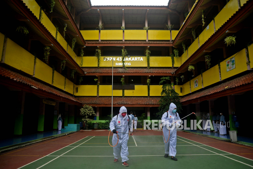 Petugas Palang Merah Indonesia (PMI) melakukan penyemprotan disinfektan di lingkungan SMP Negeri 43 Jakarta, Kamis (20/10/2022). DKI Jakarta masih mempertahankan PTM terbatas 100 persen di tengah naiknya kasus Covid-19 dan meluasnya penyebaran varian omicron.