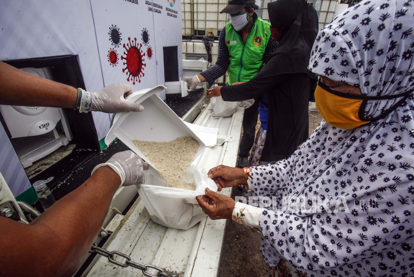 Relawan menuangkan beras gratis di ATM beras keliling Bogor Gercep di Desa Bojong Nangka, Gunung Putri, Bogor, Jawa Barat, Kamis (23/4/2020). Kegiatan tersebut guna meringankan beban ekonomi warga terdampak COVID-19 di wilayah Kabupaten Bogor