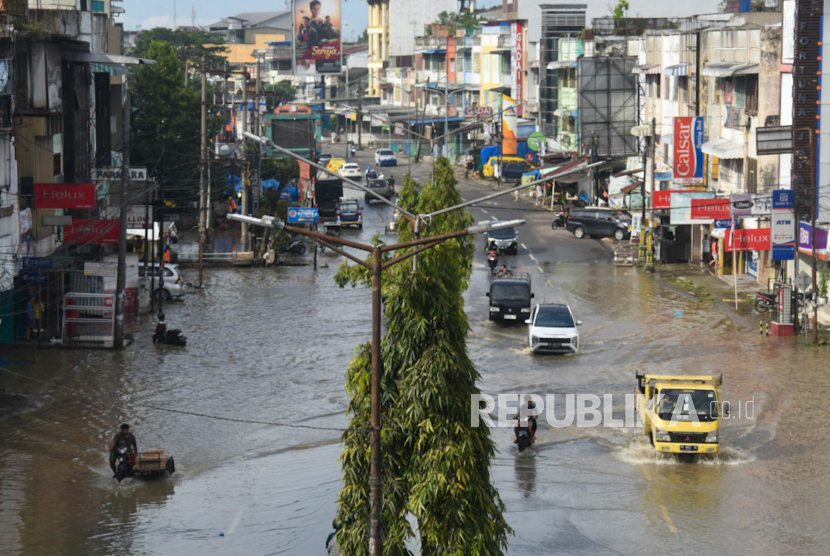 Sejumlah pengendara melintasi banjir di Jalan Yos Sudarso, Pulo Brayan,Medan, Sumatera Utara.