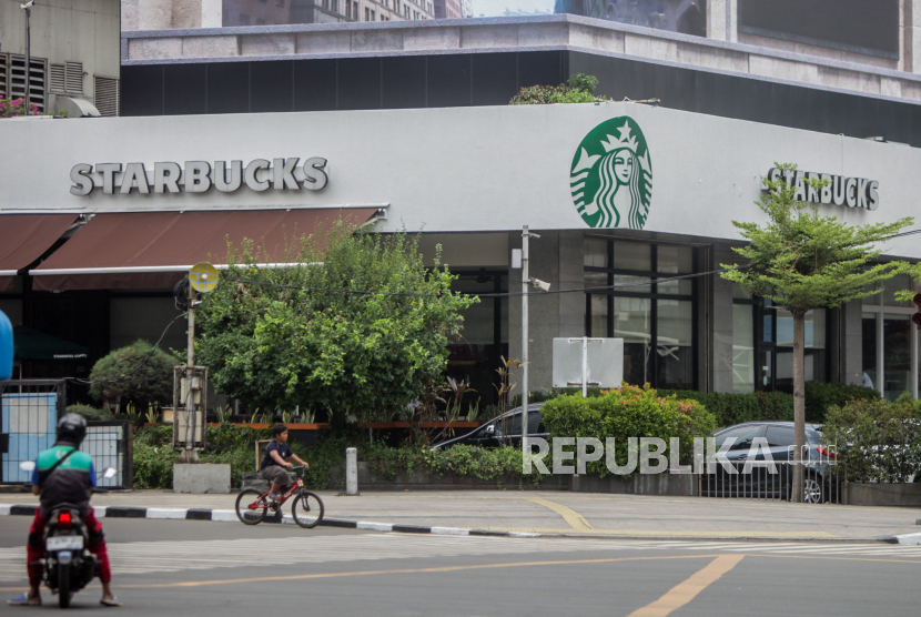 Seorang anak bersepeda di dekat gerai Starbucks yang kembali beroperasi di Jalan MH Thamrin, Jakarta, Ahad (5/11/2023). Gerai makanan cepat saji McDonalds dan Starbucks kembali beroperasi pasca Aksi Damai Aliansi Rakyat Indonesia Bela Palestina yang digelar di Monas.