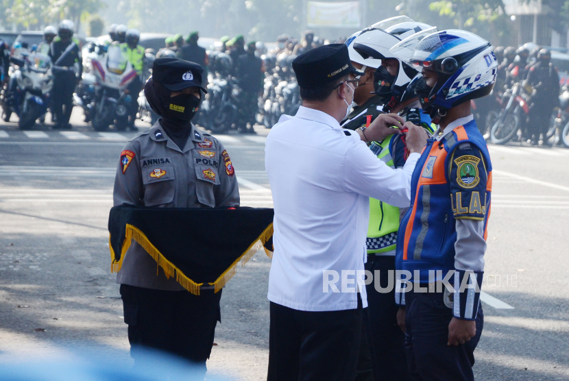 Gubernur Jawa Barat M Ridwan Kamil menyematkan pita kepada perwakilan petugas saat Apel Gelar Pasukan Operasi Ketupat Lodaya 2022, di depan Gedung Sate, Jalan Diponegoro, Kota Bandung, Jumat (22/4). 