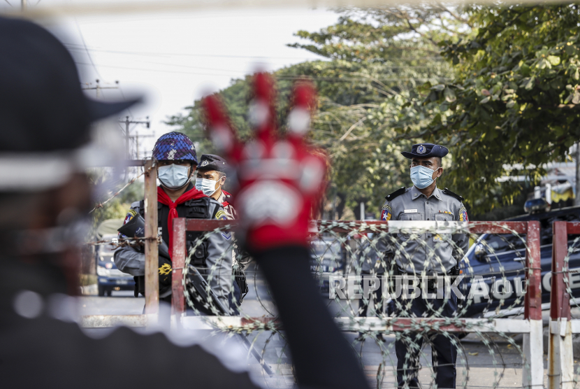 Petugas polisi berjaga-jaga di belakang barikade yang memblokir jalan menuju bank sentral ketika para demonstran melakukan protes terhadap kudeta militer di Yangon, Myanmar, 16 Februari 2021. Pemerintah militer Myanmar menggunakan hukuman mati sebagai alat untuk menghancurkan oposisi terhadap pemerintahan. Junta telah menghukum mati lebih dari 130 penentang rezim sejak Februari 2021.