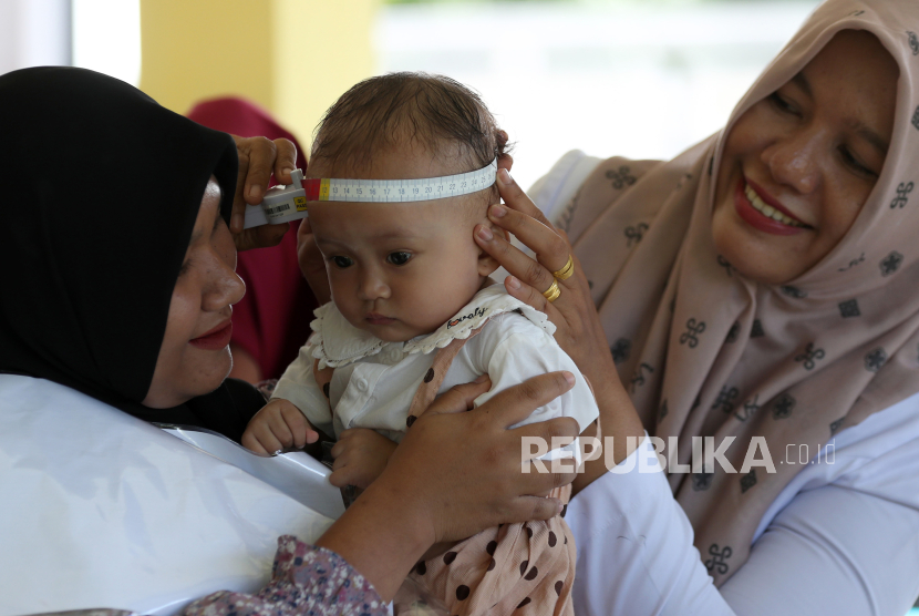 Petugas dinas kesehatan mengukur besar kepala bayi pada aksi timbang serentak untuk pencegahan stunting di gampong (desa) Pande, Banda Aceh, Aceh, Rabu (2/8/2023). Aksi timbang serentak di seluruh posyandu itu untuk menurunkan angka stunting nasional yang ditargetkan Kementerian Kesehatan dari 21,6 persen pada tahun 2022 menjadi 14 persen pada 2024 mendatang.