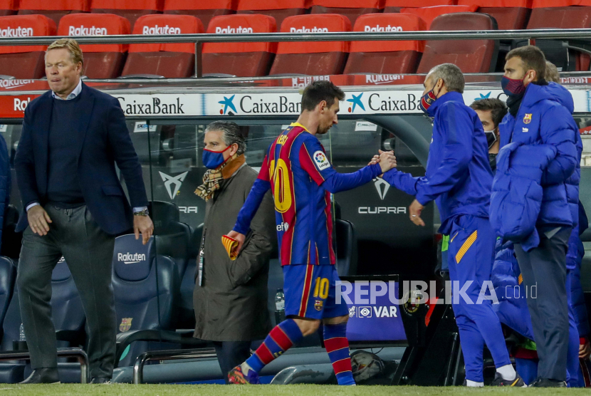 Bintang Barcelona Lionel Messi (tengah), meninggalkan lapangan melewati pelatih Barca Ronald Koeman (kiri).