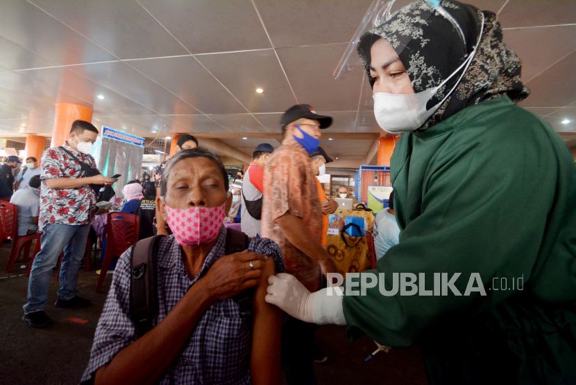 Petugas kesehatan menyuntikkan vaksin COVID-19 kepada seorang pedagang, di Pasar Raya Padang, Sumatera Barat, Kamis (4/3/2021). Pemkot Padang melalui Dinas Perdagangan melakukan vaksin COVID-19 kepada pedagang, petugas pelayan publik, dan warga di Pasar Raya Padang dengan target 2.500 orang selama dua hari. ANTARA FOTO/Iggoy el Fitra/rwa.