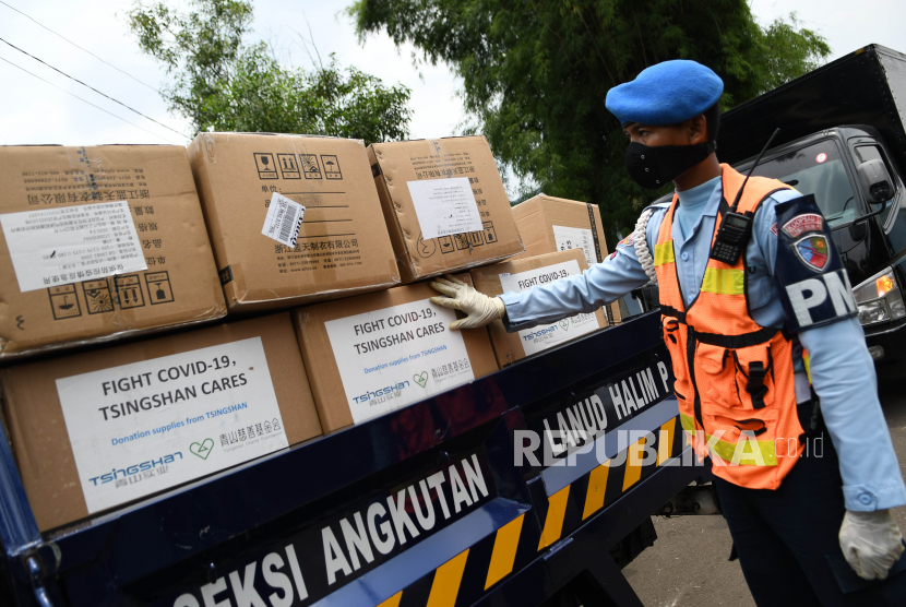 Prajurit TNI AU mengecek kardus berisi alat kesehatan untuk penanganan COVID-19 dari Shanghai, China di Lanud Halim Perdanakusuma, Jakarta.