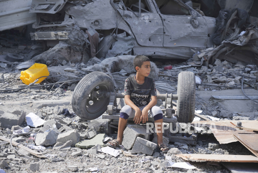 Anak Palestina duduk di reruntuhan rumahnya usai diserang Israel sementara para pengungsi Israel disediakan kamar hotel