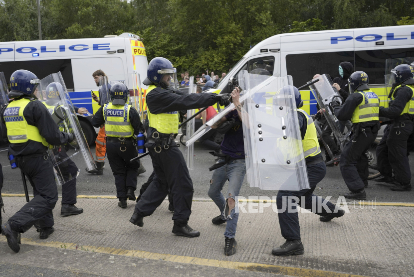 Petugas kepolisian bentrok dengan massa aksi saat terjadi kerusuhan demonstrasi anti-imigrasi di area Holiday Inn Express di Rotherham, Inggris, Ahad (4/8/2024).