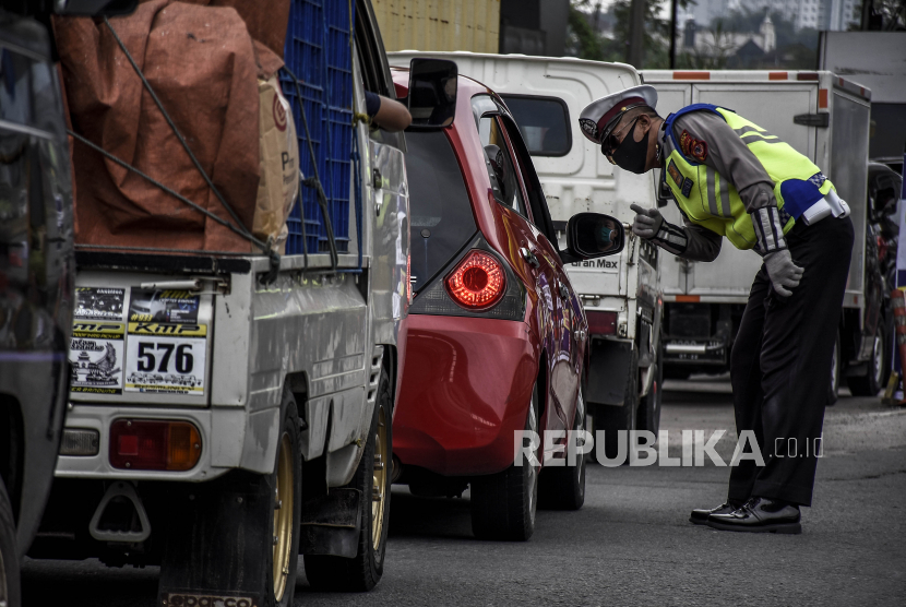 Petugas kepolisian memeriksa kendaraan di pos pemeriksaan Pembatasan Sosial Berskala Besar (PSBB) di Gerbang Tol Cileunyi, Kabupaten Bandung, Selasa (28/4). (ilustrasi)