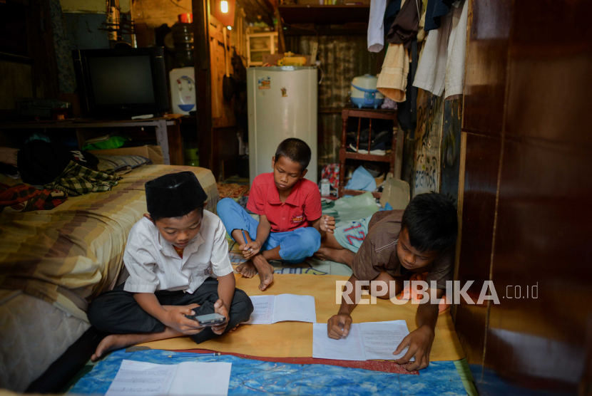 Adi Pratama siswa MI Ruhul Islam kelas enam (kanan) bersama adiknya Aldi (tengah) dan tetangganya Arga Mahendra (kiri) belajar di rumahnya secara online di kawasan Kampung Penampungan Gasong, Jakarta.. Mereka belajar menggunakan satu buah handphone yang digunakan secara bergiliran akibat keterbatasan fasilitas smartphone. (ilustrasi)