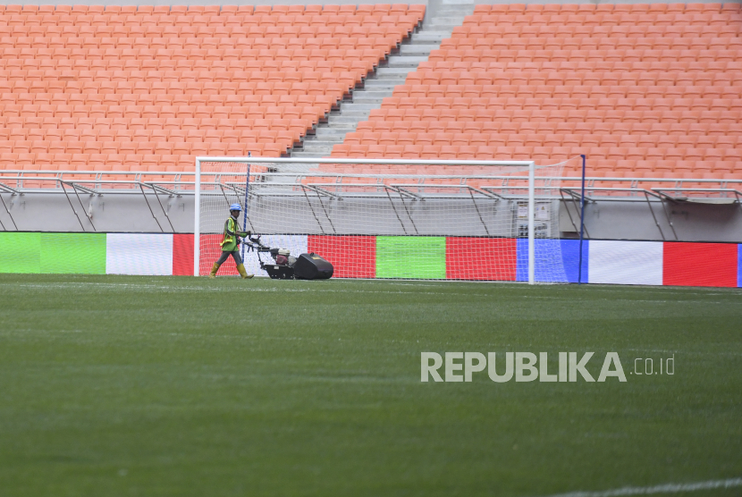 Pekerja memotong rumput lapangan di Jakarta International Stadium, Jakarta, Selasa (12/4/2022). Ajang sepak bola International Youth Championship 2021 (IYC 2021) akan digelar di Jakarta International Stadium pada 13,15,17, dan 19 April yang diikuti oleh empat tim yakni Barcelona U-18, Atletico Madrid U-18, Indonesia All Star U-20, dan Bali United U-18. 