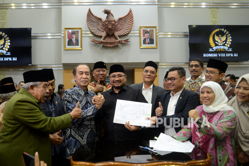 Ketua Komisi VIII DPR RI Ashabul Kahfi beajabat tangan dengan Menteri Agama Yaqut Cholil Qoumas usai menandatangani penetapan Biaya Penyelenggaraan Ibadah Haji (BPIH) di kompleks Parlemen, Senayan, Jakarta, Rabu (15/2/2023). 