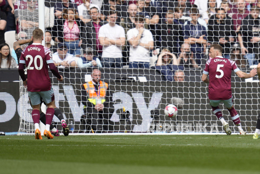 Pemain Arsenal Gabriel Jesus, kiri, tersembunyi, mencetak gol pembuka timnya saat pertandingan sepak bola Liga Inggris antara West Ham United dan Arsenal di stadion London di London, Ahad, (16/4/2023).