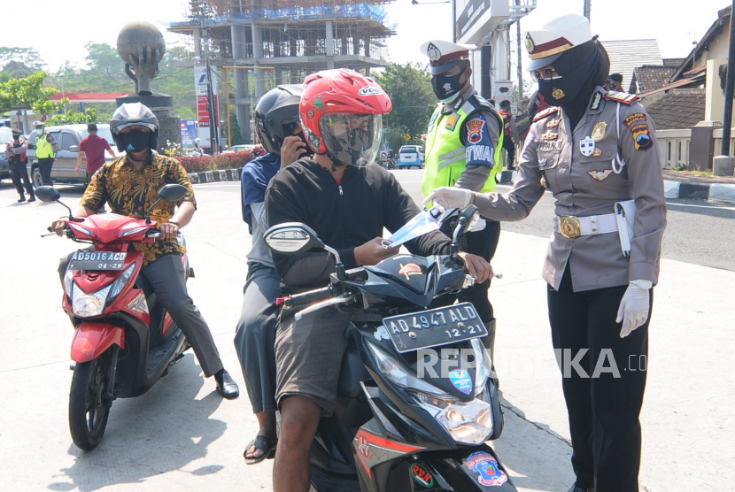 Sejumlah anggota Satlantas Polres Boyolali membagikan masker kepada pengendara motor di Boyolali, Jawa Tengah. 