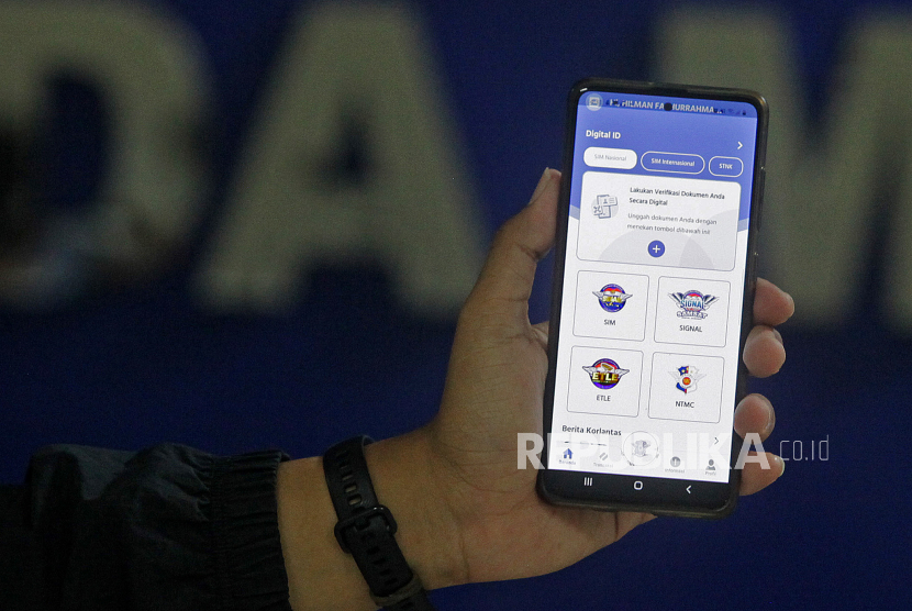 Petugas menunjukkan aplikasi SIM Nasional Presisi Korlantas Polri (Sinar) saat peluncurannya untuk guna perpanjangan SIM secara daring di Jakarta, Selasa (13/4/2021). Kapolri meluncurkan aplikasi Sinar untuk perpanjang SIM secara daring agar masyarakat dapat melakukan pembuatan dan perpanjangan SIM A dan SIM C dari mana saja secara online dengan mengunduh platform digital Korlantas di Android maupun Apple.  