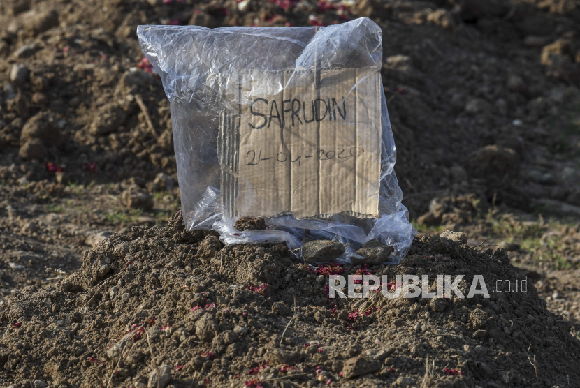 Tanda pengenal yang terbuat dari kardus sebagai pengganti nisan berada di pusara warga yang meninggal akibat Covid-19 di TPU Tegal Alur, Jakarta Barat.