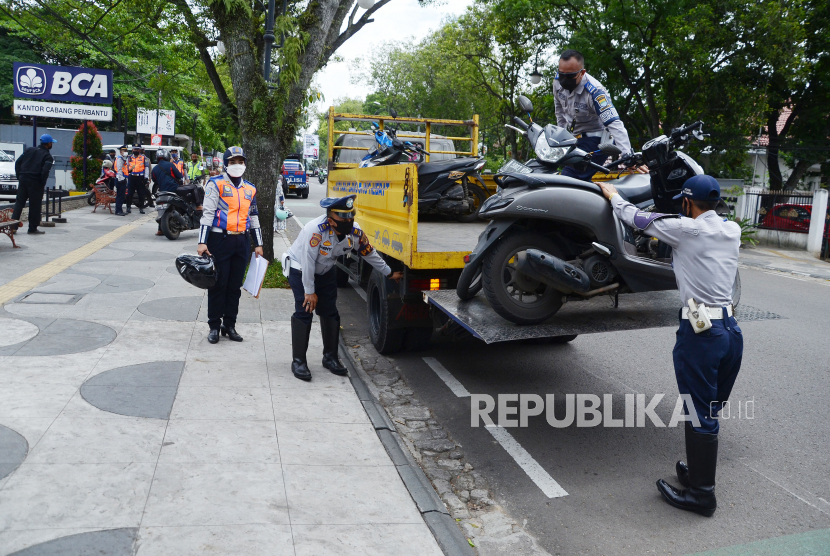 Petugas Dinas Perhubungan (Dishub) Kota Bandung menaikan sejumlah sepeda motor ke atas truk saat penertiban sepeda motor yang parkir sembarangan di trotoar, Jalan LRE Martadinata, Kota Bandung. (Ilustrasi)