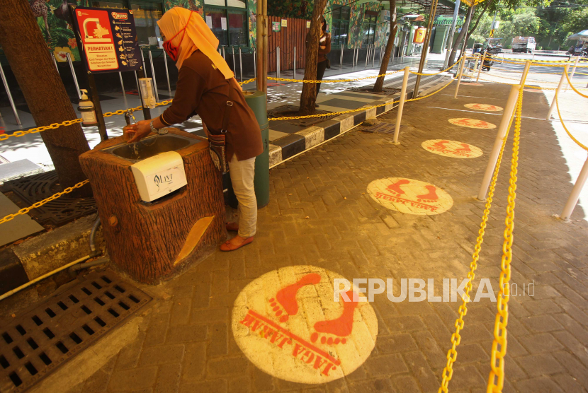 Pekerja mencuci tangan di depan loket Kebun Binatang Surabaya (KBS), Surabaya, Jawa Timur..