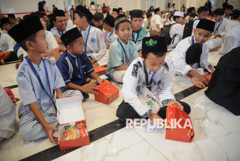 Sejumlah Anak yatim menanti waktu berbuka saat acara Buka Puasa Bersama 1000 Anak Yatim di Masjid At-Thohir, Depok, Jawa Barat, Jumat (14/3/2025). AlamTri menggelar buka puasa bersama 1000 Anak yatim dengan tema Bersama Dalam Keberkahan, Berbagi Dalam Kebahagiaan. Buka puasa ini merupakan kegiatan rutin tahunan sejak tahun 2011 untuk memberikan momen kebahagiaan bagi anak-anak yatim serta mempererat silaturahmi dan rasa syukur dengan berbagi kebaikan di bulan suci Ramadan. Acara ini diisi dengan tausiah, pemberian santunan kepada anak yatim, serta dilengkapi dengan konsep food festival.