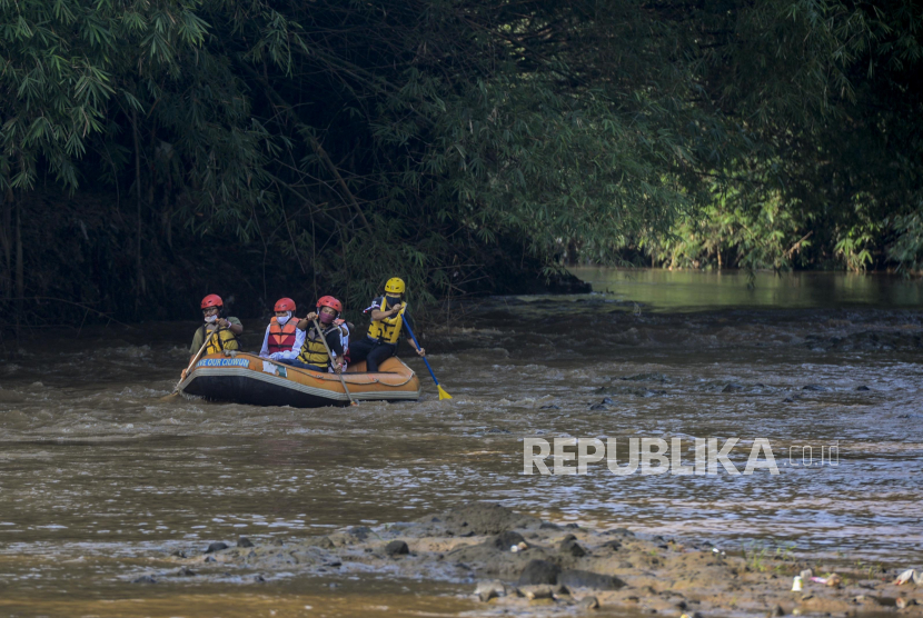 Warga menaiki perahu karet menyusuri Sungai Ciliwung.