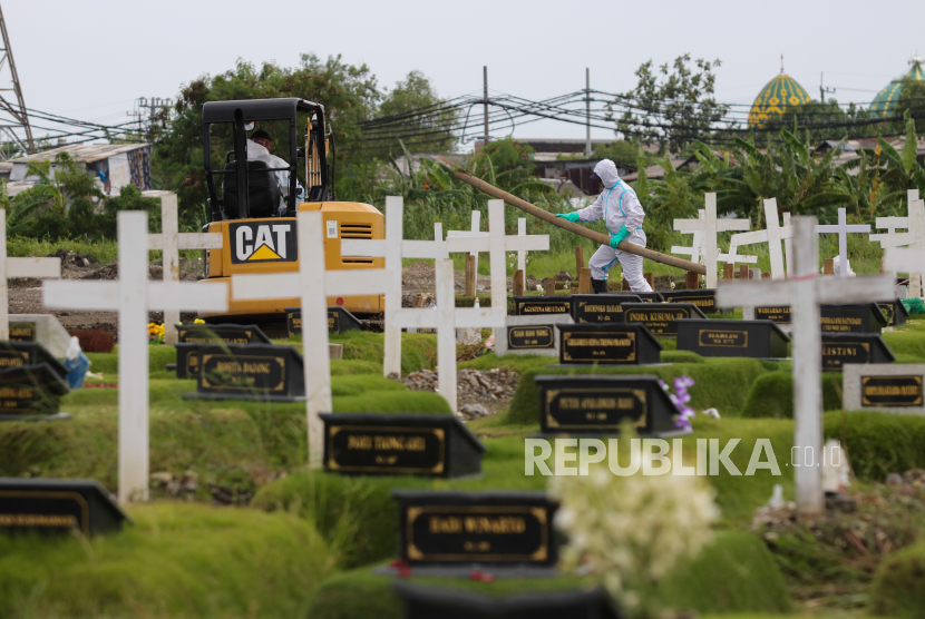 Petugas menyiapkan liang lahat untuk pemakaman jenazah dengan protokol COVID-19 di Tempat Pemakaman Umum (TPU) Keputih, Surabaya, Jawa Timur, Senin (1/2/2021). Menurut data dari UPTD Pemakaman Dinas Kebersihan dan Ruang Terbuka Hijau Kota Surabaya, tercatat sampai  tanggal 27 Januari 2021 telah dimakamkam secara protokol COVID-19 sebanyak 2.693 jenazah di TPU Keputih, sebanyak 1.282 jenazah di TPU Babat Jerawat dan dikremasi sebanyak 360 jenazah. 