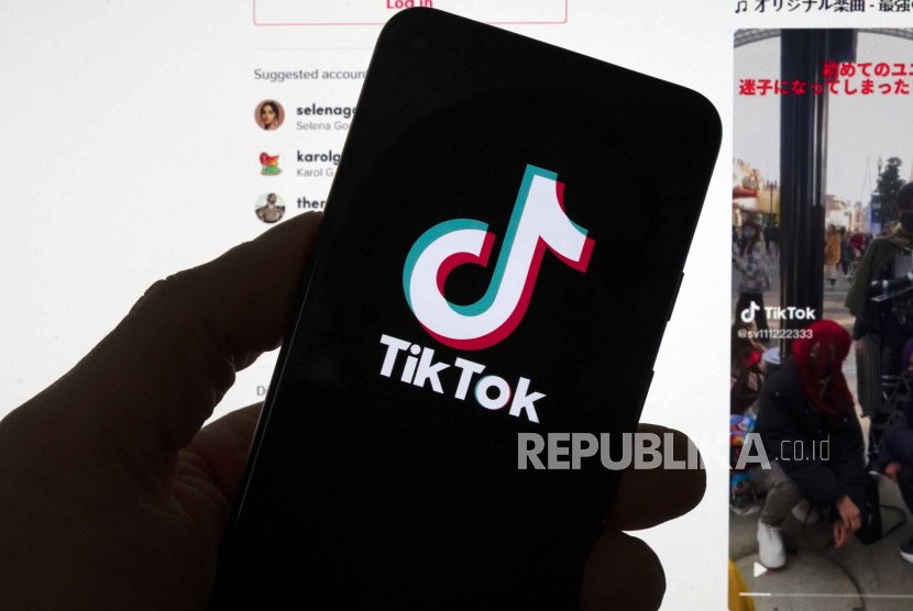 Logo TikTok terlihat di ponsel di depan layar komputer yang menampilkan layar utama TikTok, 18 Maret 2023, di Boston. Naskah Khutbah Jumat: 5 Pedoman Berperilaku di Media Sosial