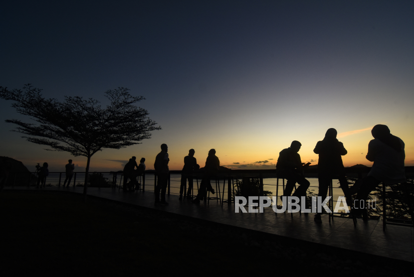 Pengunjung menikmati suasana matahari terbenam di kawasan Taman Wisata Alam (TWA) Gunung Tunak di Desa Mertak, Kecamatan Pujut, Lombok Tengah, NTB, Senin (6/6/2022). TWA Gunung Tunak seluas 1.219,97 hektare yang dikelola oleh Balai Konservasi Sumber Daya Alam (BKSDA) NTB dan berada di daerah penyangga Destinasi Super Prioritas (DSP) Mandalika tersebut menawarkan berbagai destinasi wisata dalam satu lokasi seperti wisata pantai, lokasi berkemah serta penangkaran kupu-kupu dan rusa. Destinasi Desa Wisata di Lombok Tengah Siap Sambut Penonton WSBK