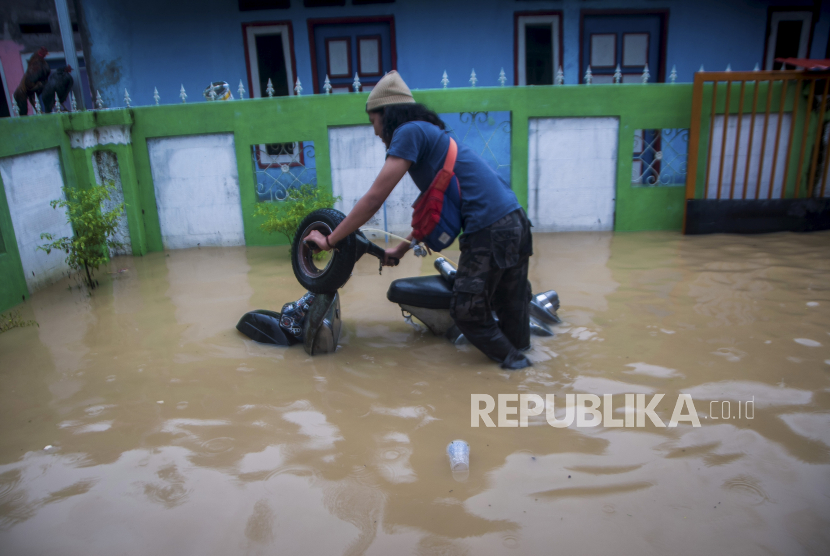 Warga mendorong kendaraannya saat banjir merendam pemukimannya, di Rangkasbitung, Lebak, Banten, Senin (7/12/2020). Berdasarkan data sementara BPBD Kabupaten Lebak banjir terus meluas hingga merendam sebanyak 1.880 rumah yang tersebar di 20 kecamatan di Lebak menyebabkan sekitar seribu warga mengungsi. 