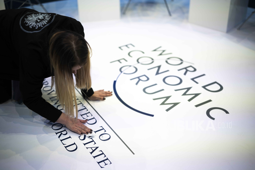 Seorang wanita membersihkan logo WEF, pada hari pertama pertemuan tahunan Forum Ekonomi Dunia (WEF) ke-54, di Davos, Swiss, (15/1/2024).
