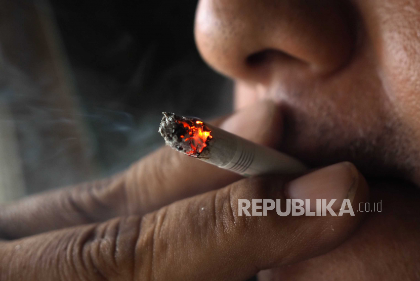  Seorang pria merokok di sebuah jalan di Jakarta, Indonesia, 31 Mei 2021. 