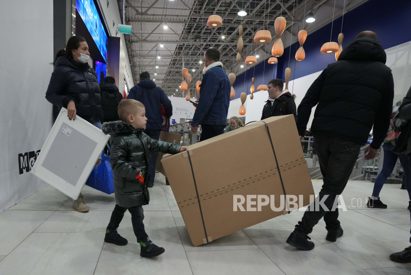 Orang-orang membawa pembelian mereka saat toko IKEA tutup di pinggiran St. Petersburg, Rusia, Kamis, 3 Maret 2022.