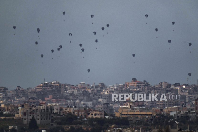 Parachutes drop supplies into the northern Gaza Strip, as seen from southern Israel, Friday, March 8, 2024. 