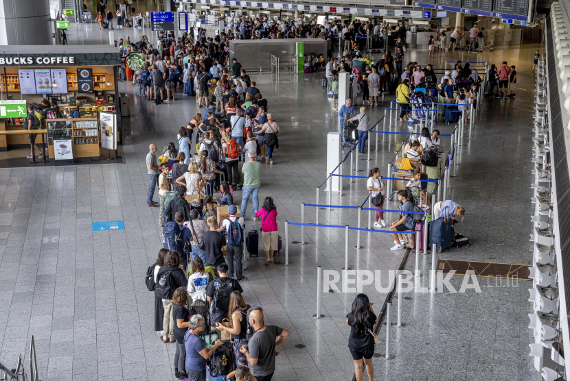  Penumpang mengantre di konter check-in di bandara di Frankfurt, Jerman, Senin, 25 Juli 2022. Uni Eropa (UE) memutuskan sepenuhnya menangguhkan perjanjian fasilitasi visa dengan Rusia pada Jumat (9/9/2022). 