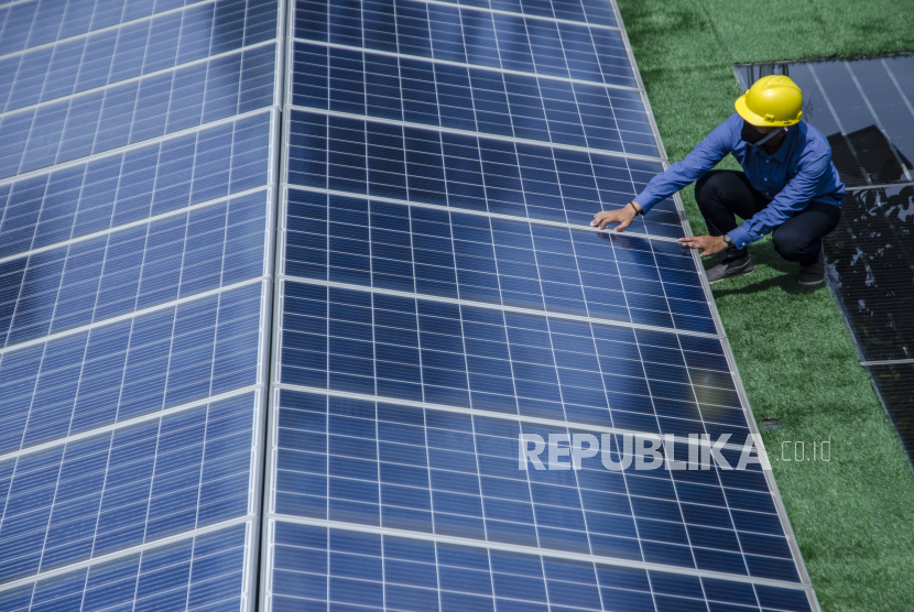Teknisi melakukan pemeriksaan rutin pada panel surya pembangkit listrik tenaga surya (PLTS) atap (ilustrasi).