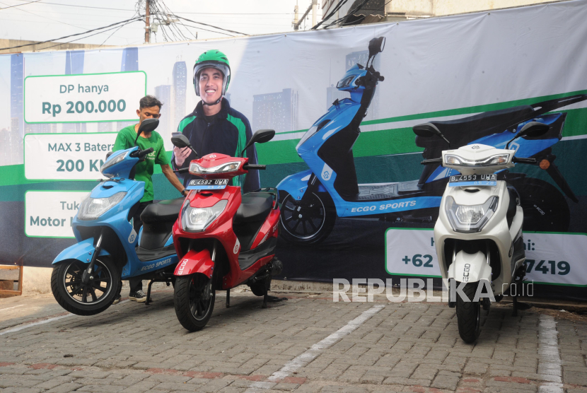 Pekerja memarkirkan motor listrik ECGO 3 di Jakarta, Senin (13/11/2023).