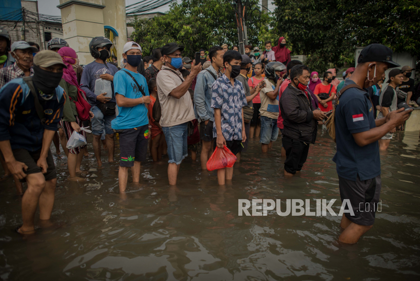 Pekerja menunggu angkutan untuk melintasi banjir rob di kawasan Pelabuhan Nizam Zachman, Jakarta Utara, Jumat pekan lalu. Banjir rob setinggi sekitar 20-60 centimeter tersebut terjadi akibat air laut pasang yang merendam kawasan pelabuhan dan pemukiman warga.