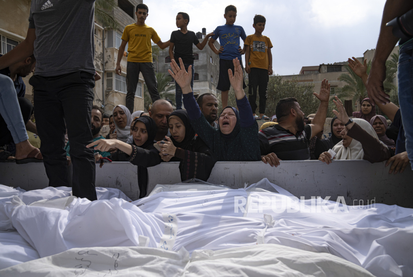 Kerabat berduka atas korban tewas dalam serangan udara Israel di Kota Gaza pada Senin, (9/10/2023).