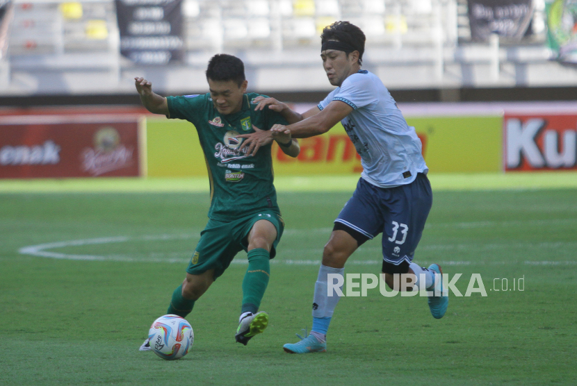 Pesepak bola Persebaya Sho Yamamoto (kiri) berusaha melewati pesepak bola Persita Sin Yeong Bae (kanan) dalam pertandingan Liga 1 di Stadion Gelora Bung Tomo, Surabaya, Jawa Timur, Sabtu (12/8/2023). Persebaya mengalahkan Persita dengan skor 1-0. 