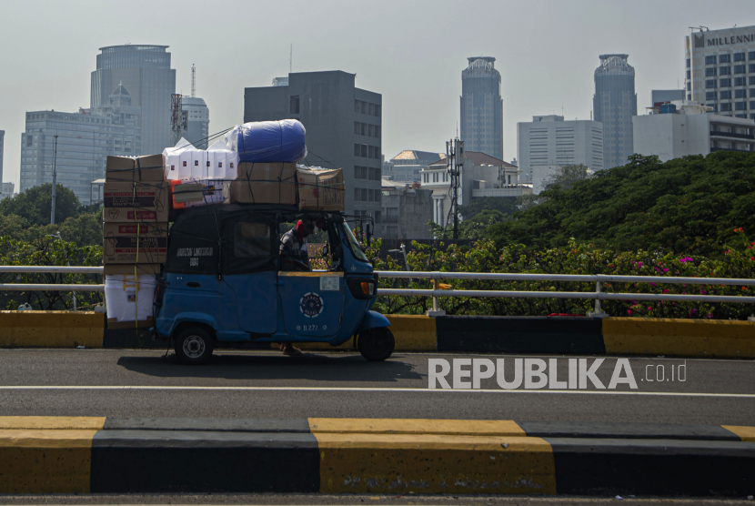 Pengemudi angkutan bajaj dengan muatan sarat barang melintas di Jembatan Cideng, Jakarta. Provinsi DKI Jakarta dan Jawa Barat menjadi dua daerah pertama penerima dana program Pinjaman Pemulihan Ekonomi Nasional (PEN) Daerah karena terdampak sangat besar oleh pandemi COVID-19 pada kesejahteraan dan ekonomi masyarakatnya. 
