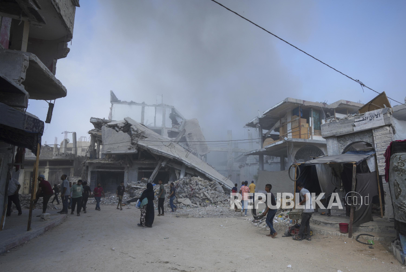 Warga Palestina berjalan melintasi puing-puing rumah yang hancur akibat serangan Israel di Khan Younis, Jalur Gaza, Senin (22/7/2024). Ribuan warga di Khan Younis melarikan diri dari serangan udara dan operasi militer Israel. Kementerian Kesehatan di Gaza yang dikuasai Hamas melaporkan serangan Israel ke Khan Younis, selatan Jalur Gaza tersebut menewaskan 70 orang dan melukai lebih dari 200 lainnya.