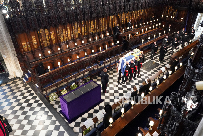  Ratu Elizabeth II dari Inggris menyaksikan para pembawa jenazah membawa peti mati Pangeran Philip dari Inggris, yang meninggal pada usia 99 tahun, di Kapel St. George, di Windsor, Inggris, 17 April 2021.