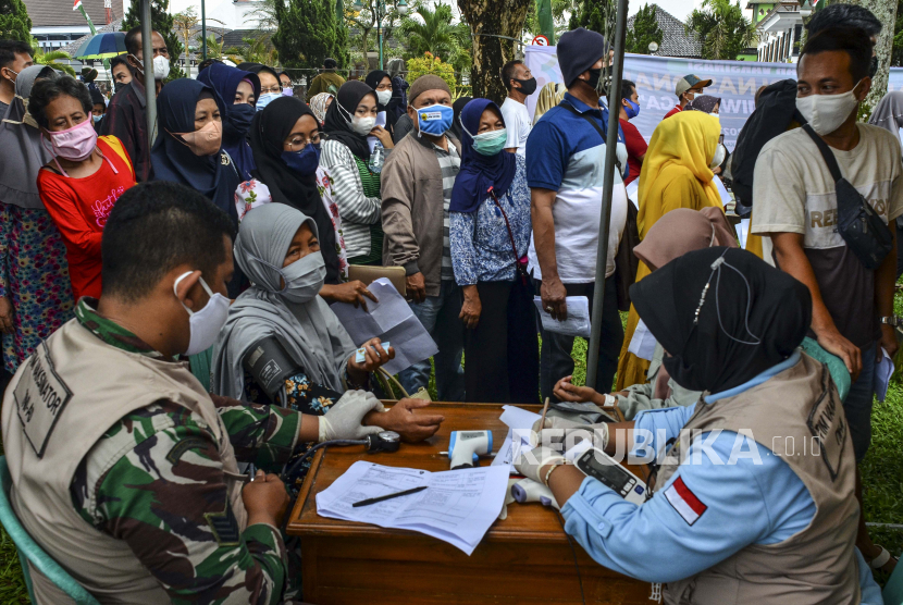 Tenaga kesehatan melakukan pemeriksaan kesehatan kepada warga pada gebyar vaksinasi COVID-19 dalam rangkaian Hari Santri Nasional di Alun-alun Kabupaten Ciamis, Jawa Barat, Sabtu (23/10/2021). Cakupan vaksinasi dosis pertama di Jabar, telah mencapai 51,33 persen atau setara dengan 19,46 juta peserta vaksin dari target yang ditetapkan sebanyak 37,91 juta orang. 