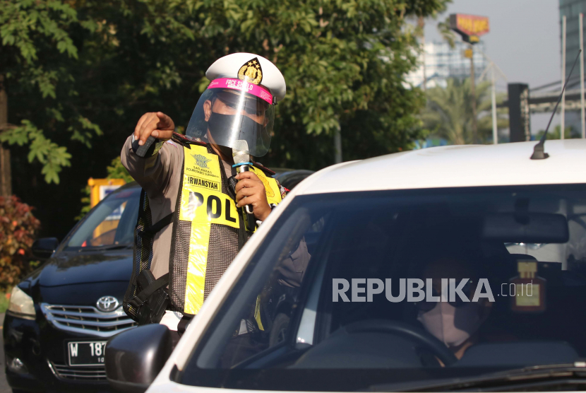 Polisi dengan menggunakan alat pelindung wajah melakukan penyekatan saat Pembatasan Sosial Berskala Besar (PSBB) Tahap III di Bundaran Waru, Surabaya, Jawa Timur, Kamis (4/6/2020). Penggunaan alat itu bertujuan untuk mengantisipasi penularan COVID-19