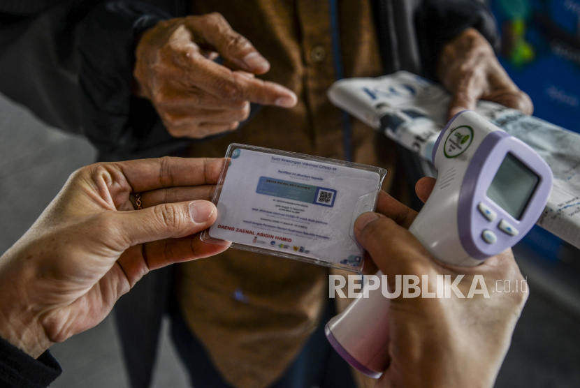 Petugas mengecek sertifikat vaksin milik calon penumpang di Halte Transjakarta Harmoni, Jakarta, Jumat (20/8).