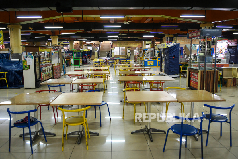 Seorang pengunjung melintas pada pusat kuliner yang sebagian tutup di kompleks Pasaraya Blok M, Jakarta, Selasa (24/3/2020). Merebaknya corona membuat pelaku UMKM merasakan dampak pahit,